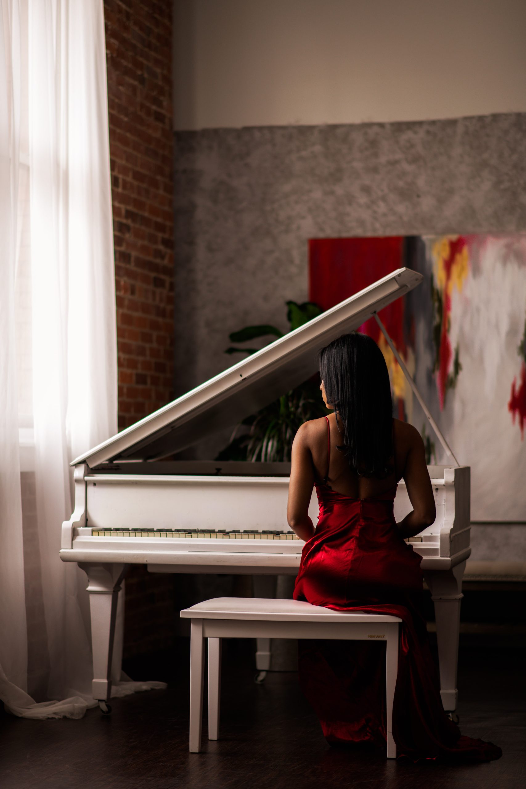 白ピアノと赤ドレスの女性